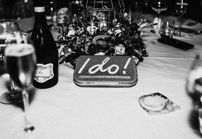 Black and white table detail with champagne and an 'I do' tin