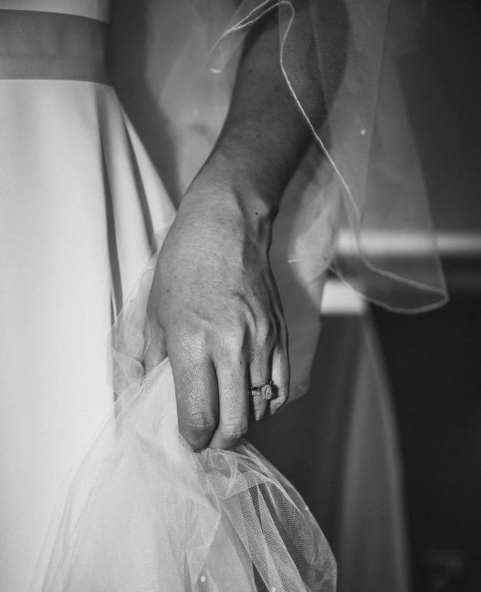 Black and white detail of a hand holding a veil