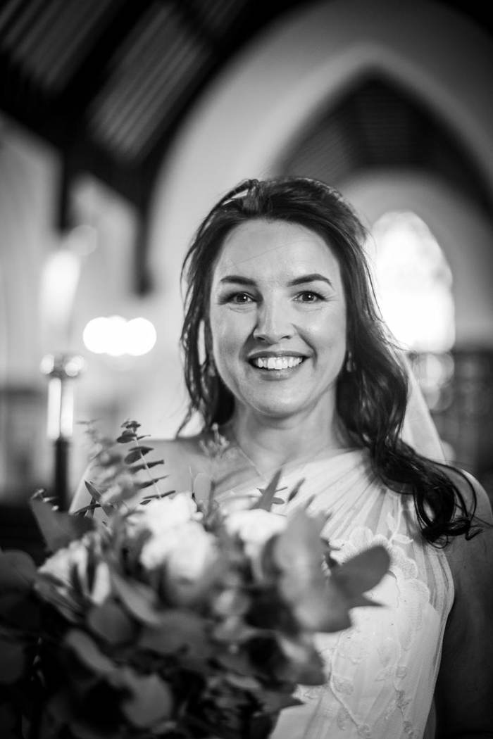 Black and white portrait of a smiling bride in a church