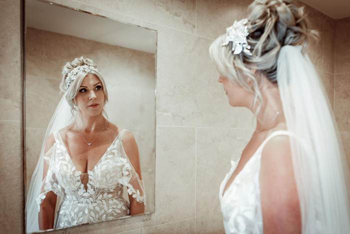 A bride checking her reflection in the mirror while getting ready