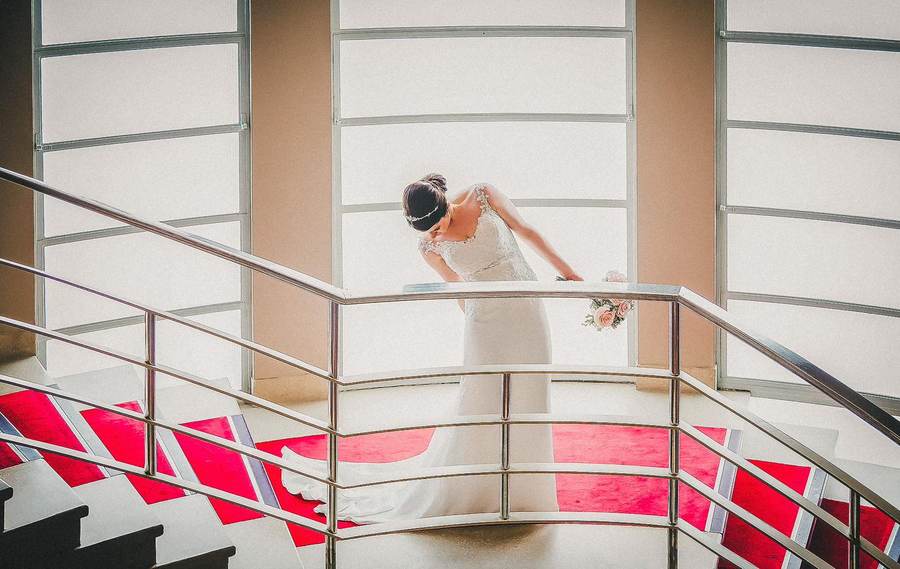 Bride on a curved staircase looking back over her shoulder